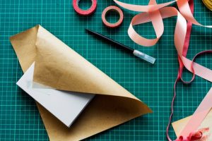 aerial-view-closeup-wrapping-box-green-cut-board_53876-41456