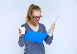 assistant-opening-blue-report-folder-checking-it_144627-58815