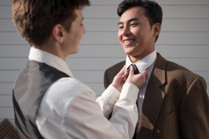 close-up-smiley-partner-arranging-tie_23-2149096470