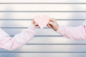 couple-holding-paper-decorative-symbol-heart_23-2148012177