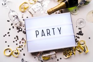 elevated-view-party-text-light-box-champagne-with-confetti-white-background_23-2148253171