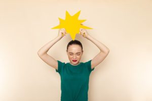 front-view-young-attractive-female-dark-green-shirt-blue-jeans-holding-yellow-sign-beige_140725-21070