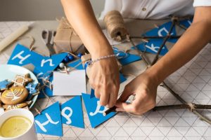 high-view-person-making-happy-hanukkah-garland_23-2148716786