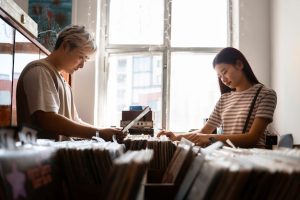 people-checking-vinyl-records-side-view_23-2149729310