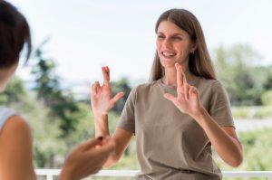smiley-woman-communicating-through-sign-language-while-outdoors_23-2148680996