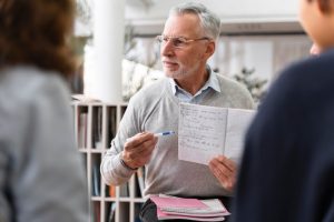 close-up-senior-man-holding-notebook_23-2149204799