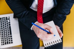 crop-man-making-notes-near-laptop_23-2147787685