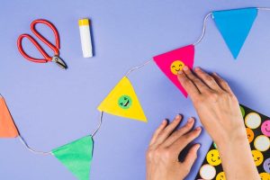 elevated-view-person-hand-sticking-emoji-sticker-bunting_23-2148193603