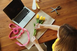 florist-work-woman-shows-how-make-bouquet-with-tulips-young-caucasian-woman-gives-online-workshop-doing-gift-present-celebration-working-home-while-isolated-quarantined-concept_155003-39534
