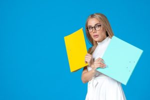 front-view-female-worker-white-dress-holding-different-folder-blue-wall_140725-149229