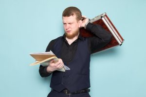 front-view-young-attractive-male-with-beard-black-dark-classic-modern-suit-holding-brown-silver-suitcase-files-blue-space_140725-12741