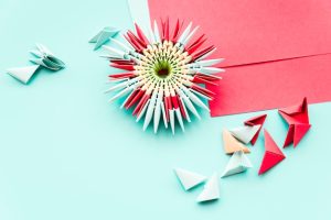 handmade-paper-flower-origami-teal-background_23-2148125264