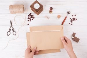 hands-with-envelope-near-set-scissors-twists-candle-usb-flash-drive_23-2148036953