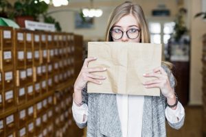 pretty-woman-covering-mouth-with-book_23-2147848142