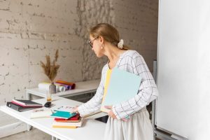 teacher-arranging-books_23-2148635362