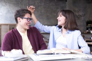 teenage-students-sitting-table-having-fun_23-2148166390