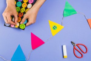 woman-hand-making-bunting-with-emoji-stickers-colored-background_23-2148193602