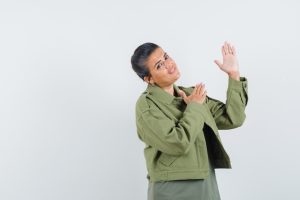 woman-showing-something-jacket-t-shirt-looking-jolly_176474-41850