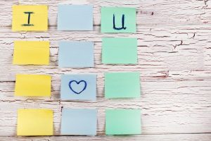 yellow-blue-green-stickers-with-lettering-i-love-youn-pinned-white-wooden-floor_1304-2844