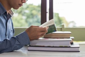 business-man-sitting-table-reading-book_1423-256