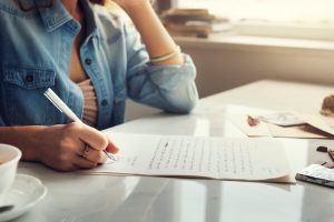 caucasian-woman-writing-letter_53876-47106