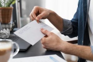 close-up-man-sealing-envelope_23-2148935060