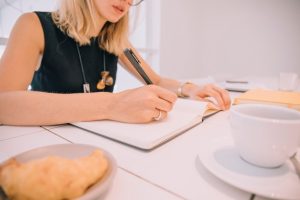 close-up-young-businesswoman-s-writing-diary-with-pen-table_23-2148066807