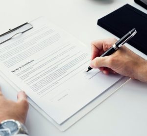 closeup-hand-signing-paper-workspace_53876-31566-2