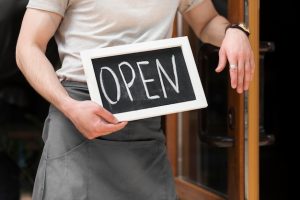 man-holding-we-are-open-sign_23-2148604359-1