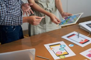 unrecognizable-colleagues-looking-tablet-trying-different-icons_1098-20485